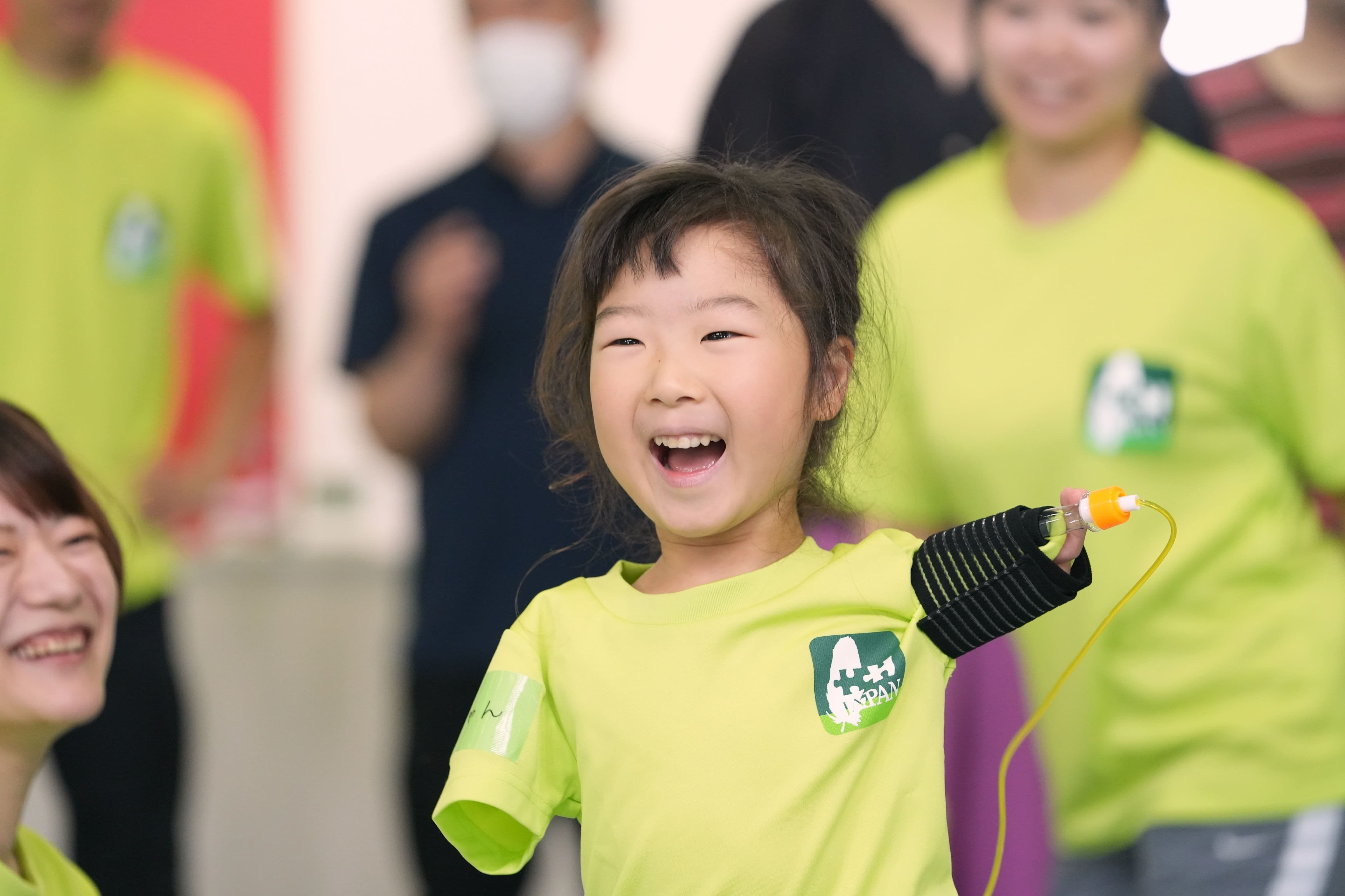 手に障がいのある子供が、開発した用具を使い運動する写真