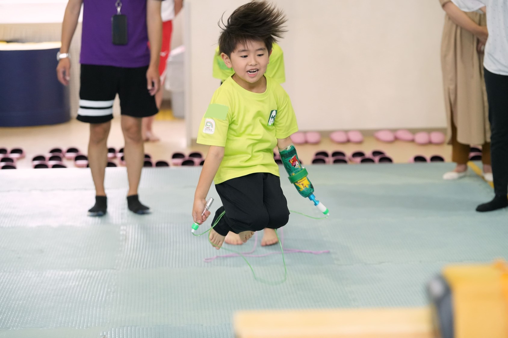 手に障がいのある子供が、開発した用具を使い運動する写真